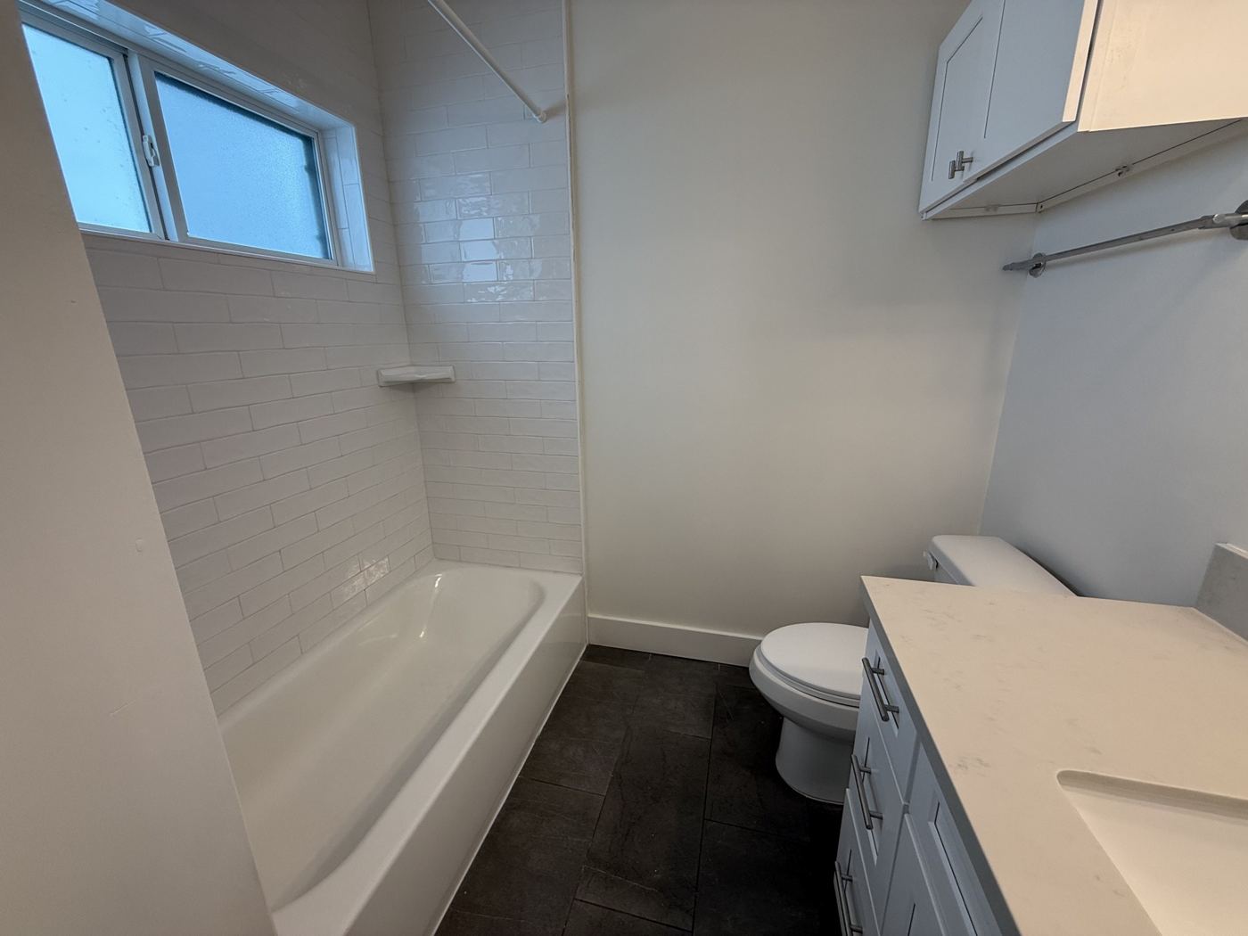 Clean bathroom with white tub, tile surround and vanity after a Houston move-out clean