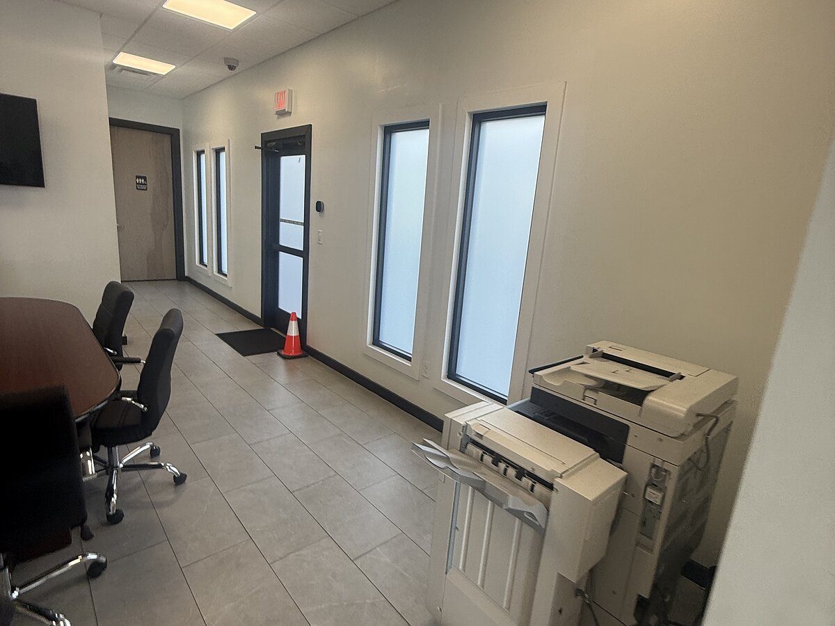 Office corridor with tile floors and a conference area after a Puretek Global Cleaning commercial clean in Houston